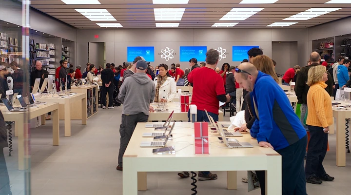 Staff assisting a customer at an Apple Store Genius Bar
